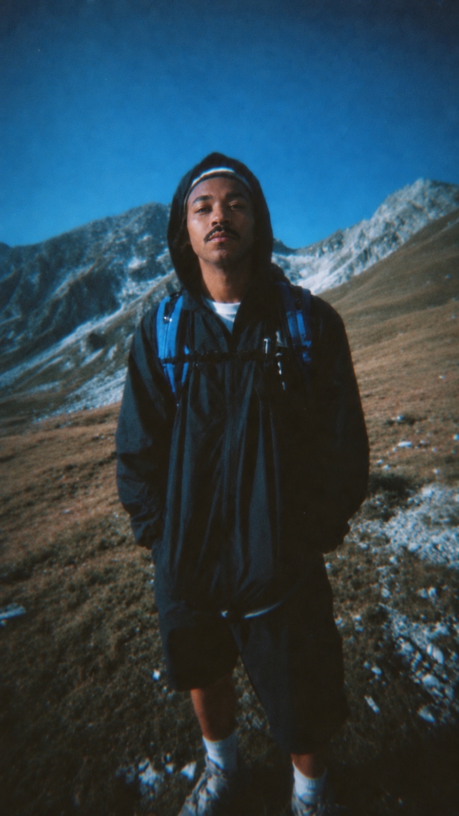Derrick J. Davis standing in the mountains